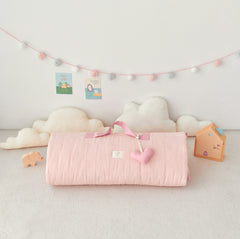 Pink rolled up portable kid's blanket with handle and heart shaped stuffed name tag