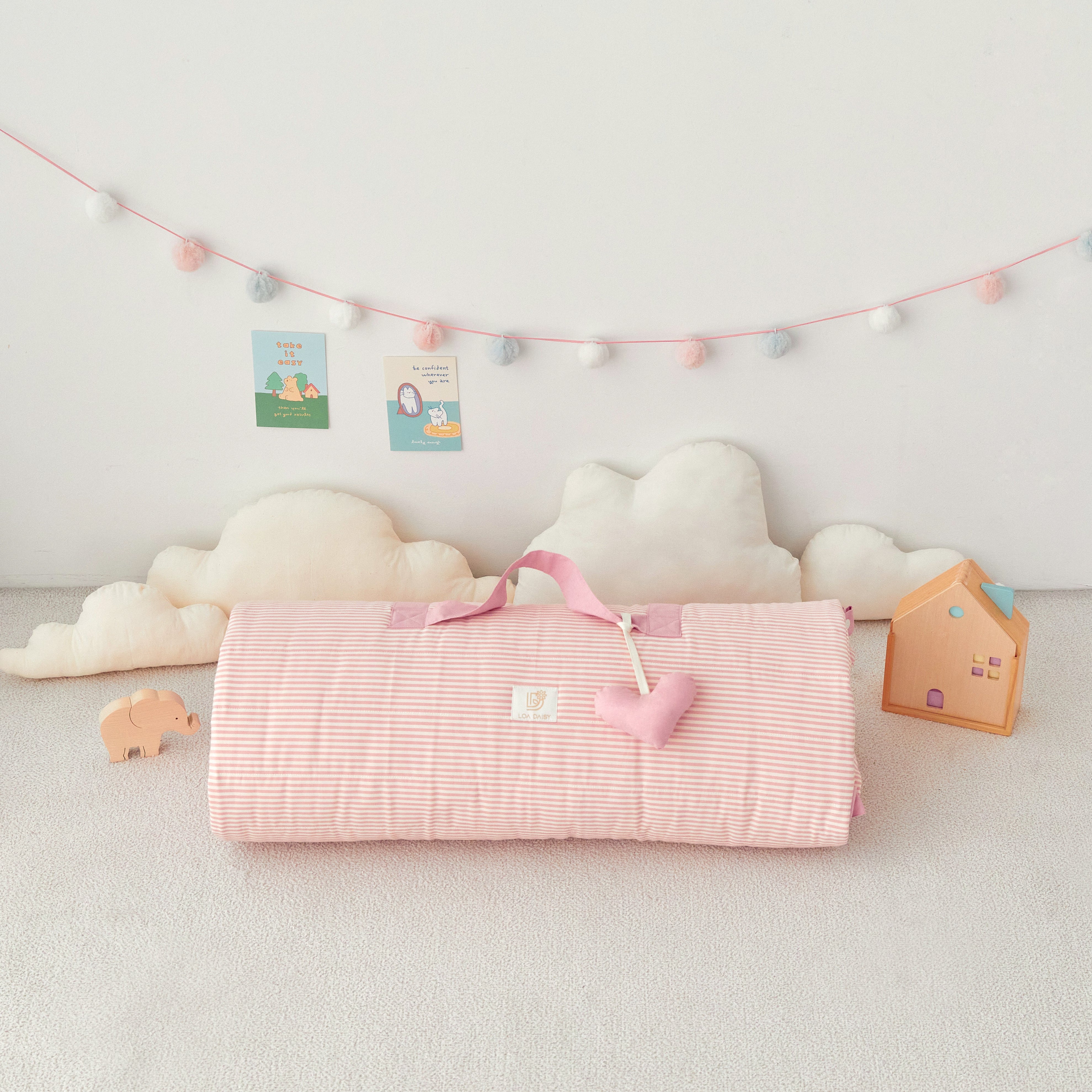 Pink rolled up portable kid's blanket with handle and heart shaped stuffed name tag