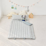 Children's room with a potable striped nap mat blanket and pillow featuring an elephant toy.