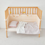 Wooden crib with baby boy blue crib blanket and pillows on a white background