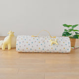 Roll-up portable nap mat blanket with a handle in yellow pink blue bunny rabbit pattern on a wooden floor with toys and a plant