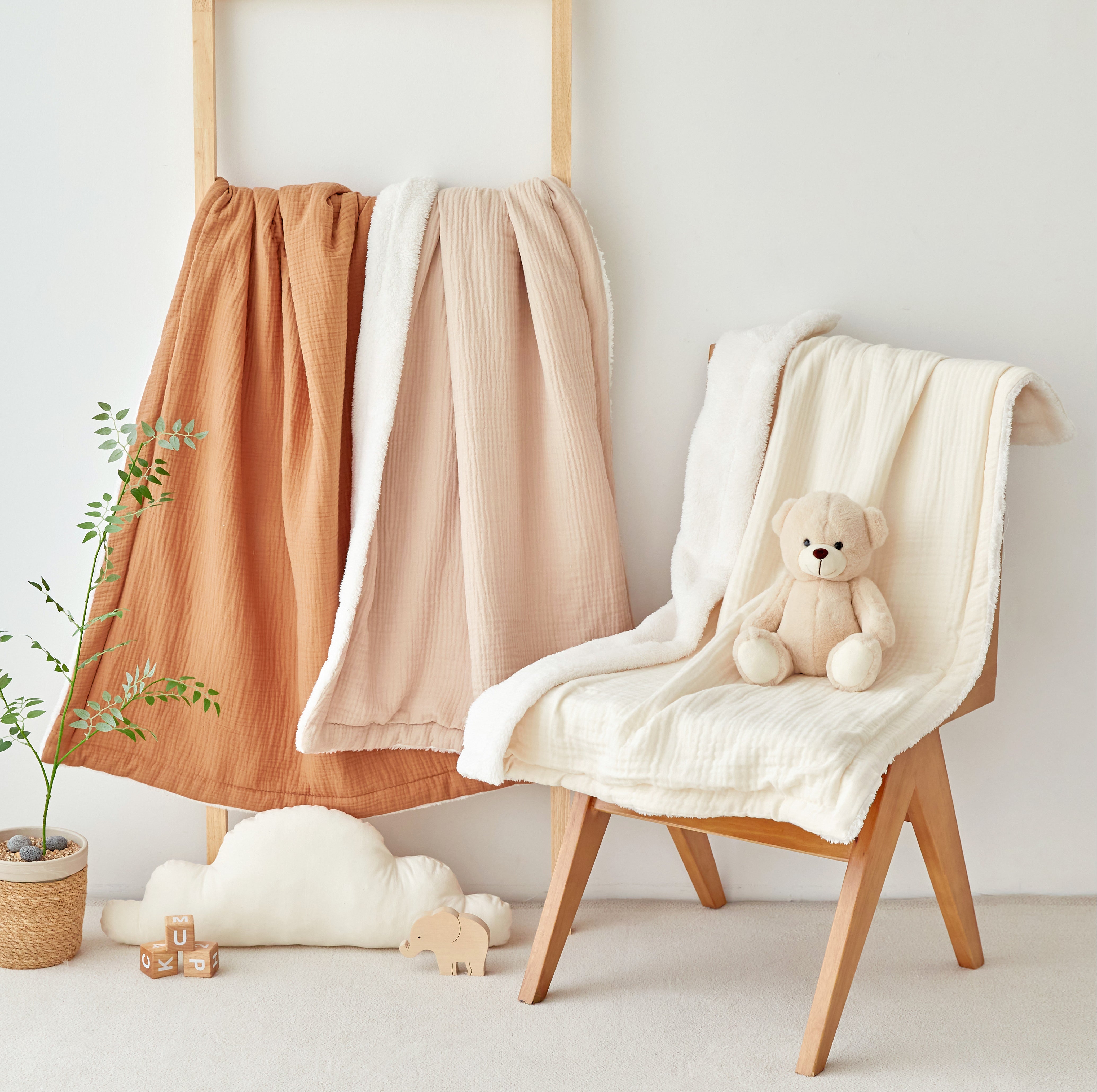 Ivory beige burnt orange gauze sherpa baby blankets draped over a chair