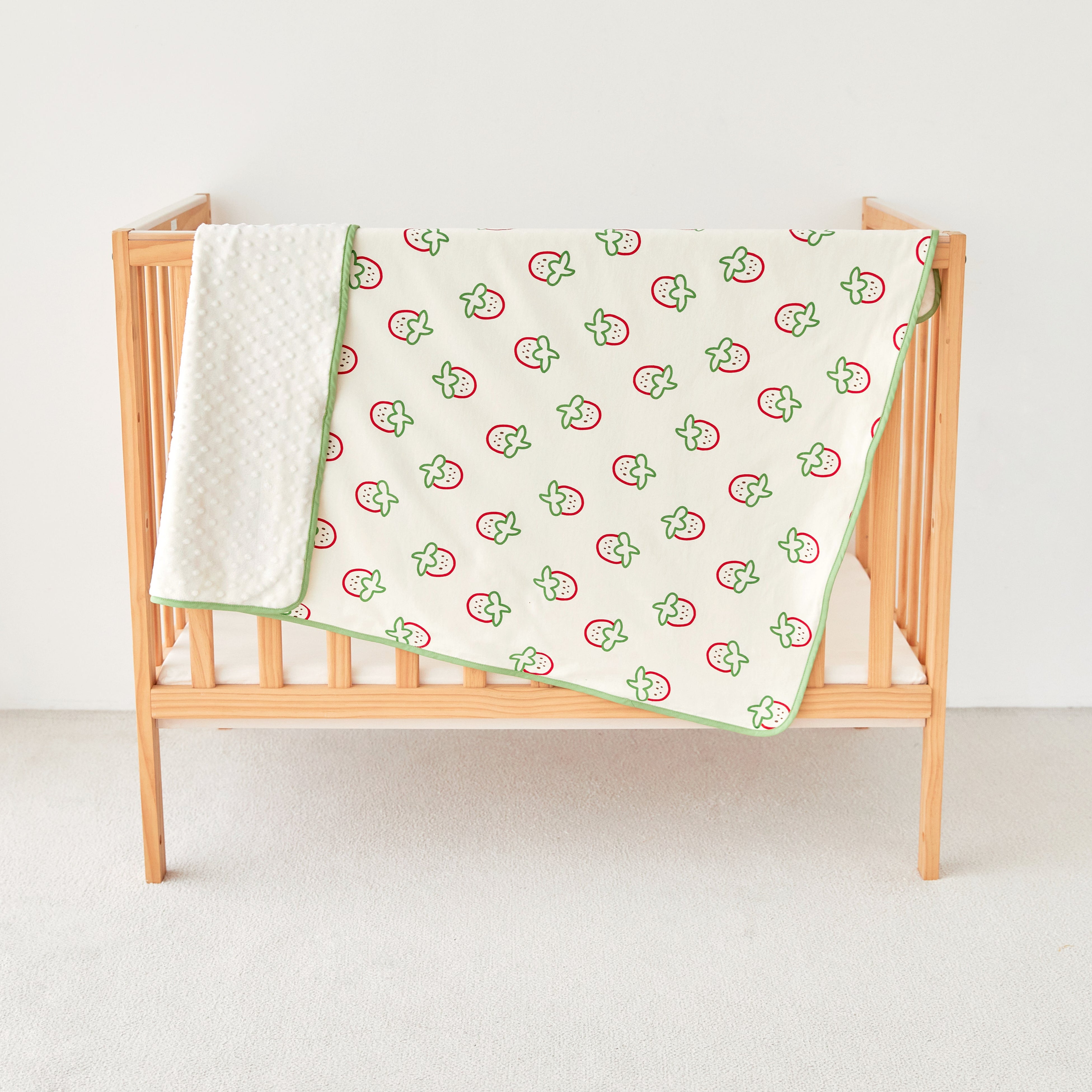Wooden crib with strawberry print kniited cotton and minky baby stroller blanket 