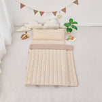 Tan Beige striped quilted nap mat blanket on a light gray floor with decorative elements.
