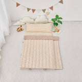 Tan Beige striped quilted nap mat blanket on a light gray floor with decorative elements.