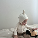 Baby wearing Cloud Soft Ivory Rib Knit Sweater styled with neutral leggings