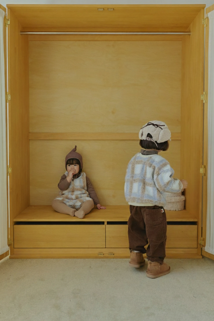 Neutral baby clothing flat lay with Cloud Dumble Sweater Soft Check and seasonal accessories