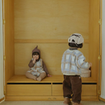 Neutral baby clothing flat lay with Cloud Dumble Sweater Soft Check and seasonal accessories