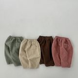 Four pairs of corduroy pants in green, beige, brown, and red on a light gray background.