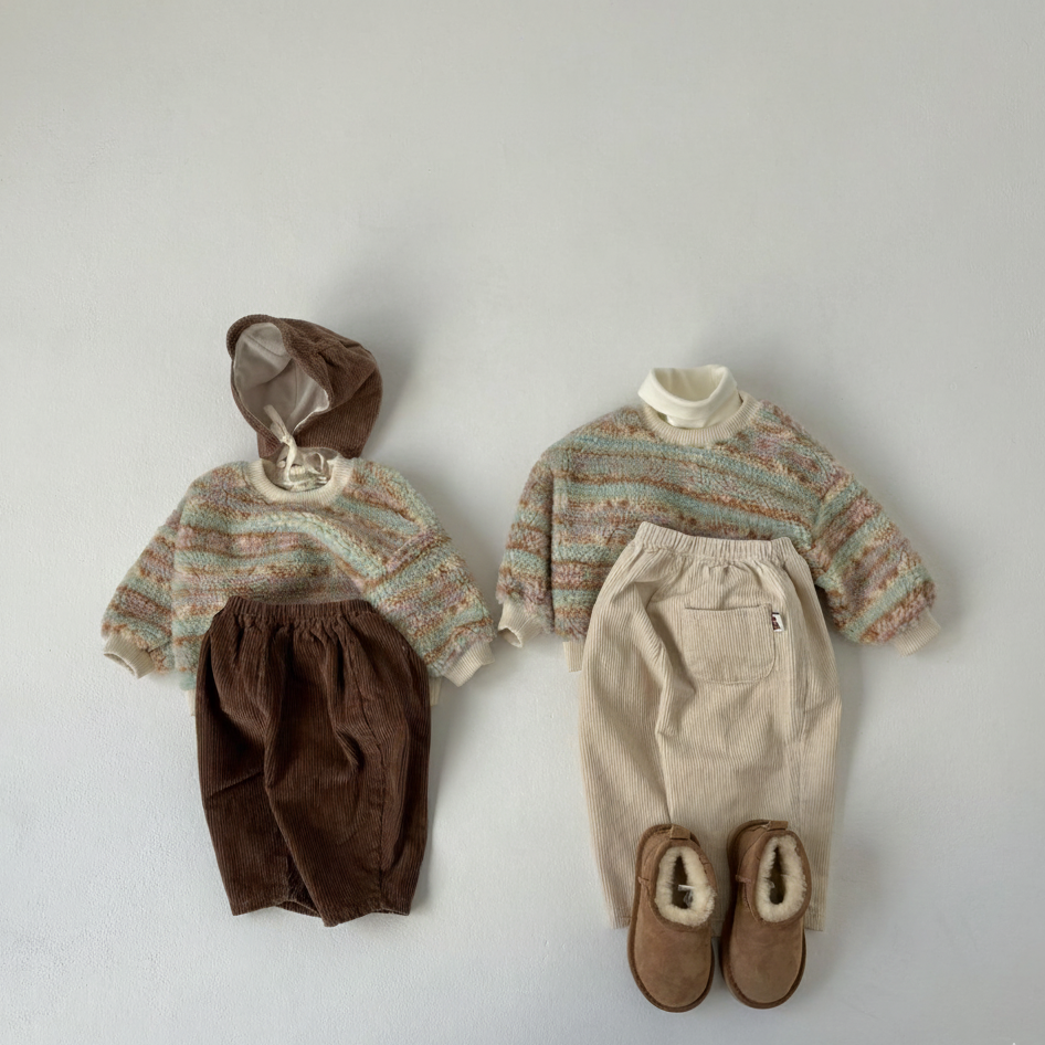 Flat lay of Corduroy Comfort Pants brown and ivory with winter sweaters on neutral background
